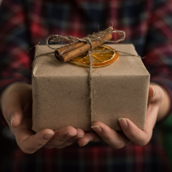 Gift box with cord ribbon, dried orange and cinnamon stick.