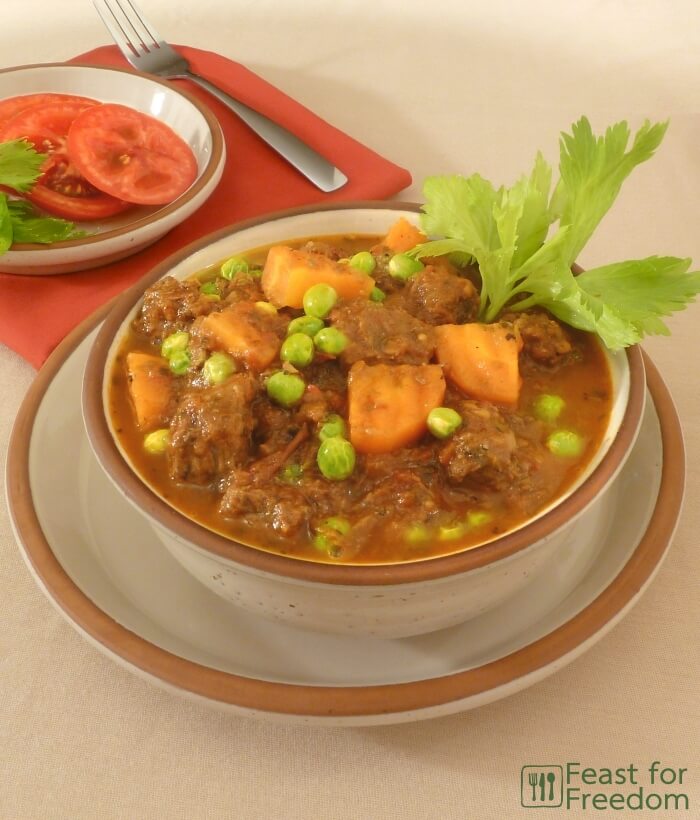 Beef stew with carrots and peas in a bowl
