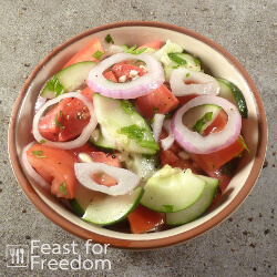Tomato cucumber salad with red onions in a bowl